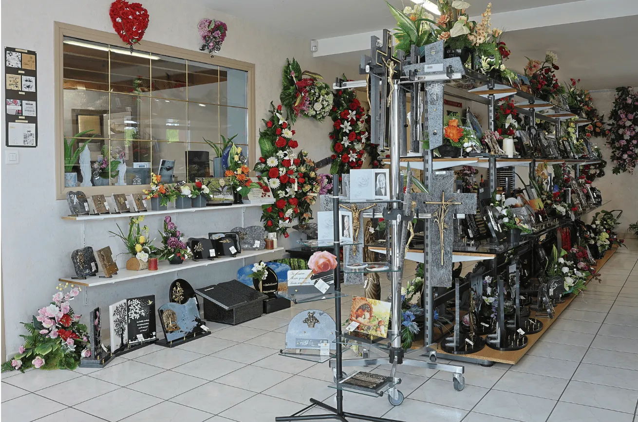 Magasin d'articles funéraires proposant plaques, croix et compositions florales.